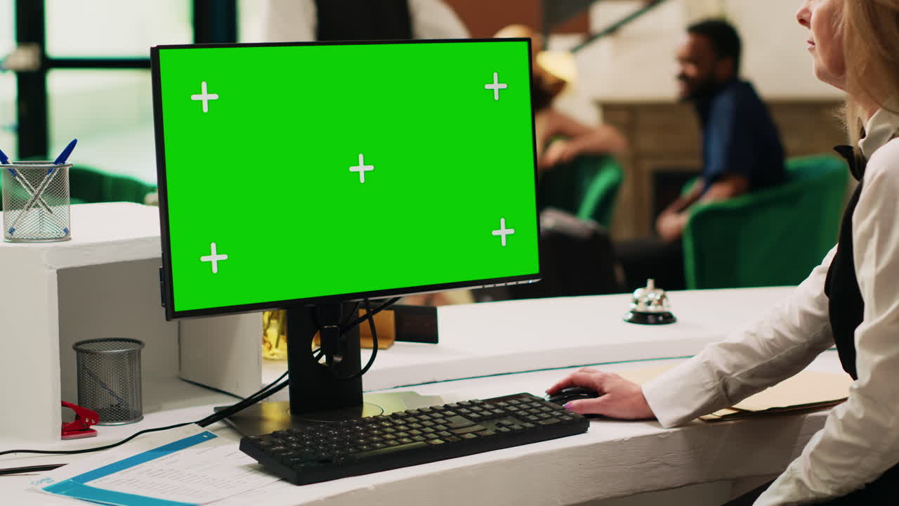 recepcionista que utiliza el ordenador de pantalla verde