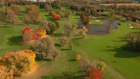 aerial view of scenic golf course with ponds and green grass during autumn - drone shot