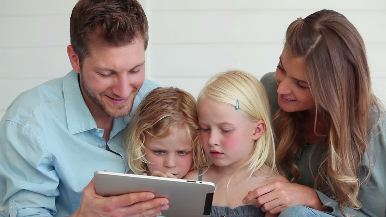 Famiglia che usa un tablet mentre sono seduti insieme