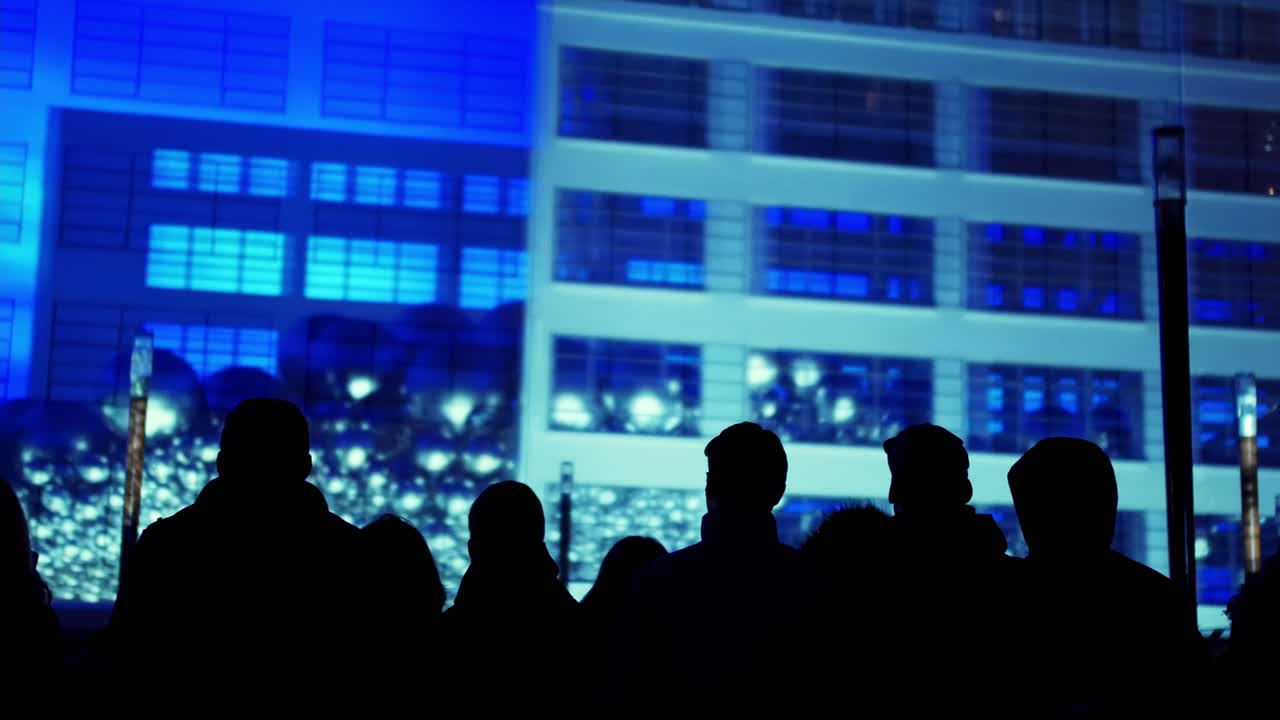 silhouette people watching light show GLOW dutch light festival balls falling