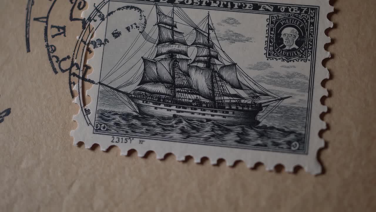 Close-up angled shot of a vintage postage stamp featuring a sailing ship, evoking nostalgia