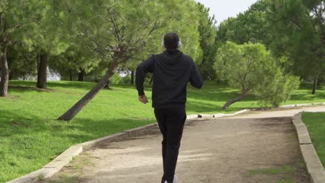 runner with headphones through the park in slow motion