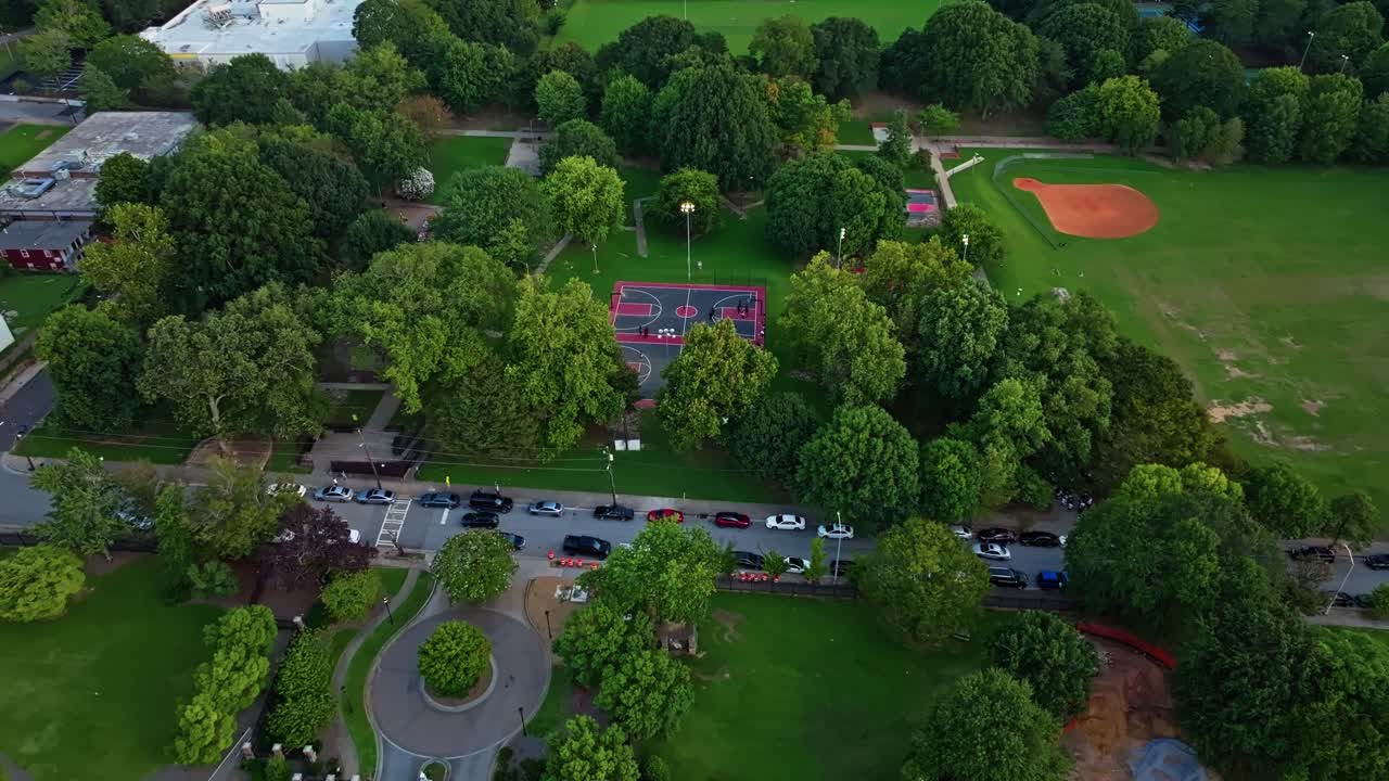 Central Park basketball court, Urban park playground, Atlanta green park neighbourhood, Cars parked in line on road, Georgia, Aerial