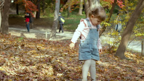 young asian girl of mixed heritage playing with leaf in park