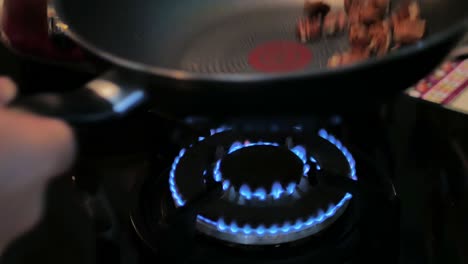 Toasting-pecan-nuts-in-wok-pan-on-gas-stove