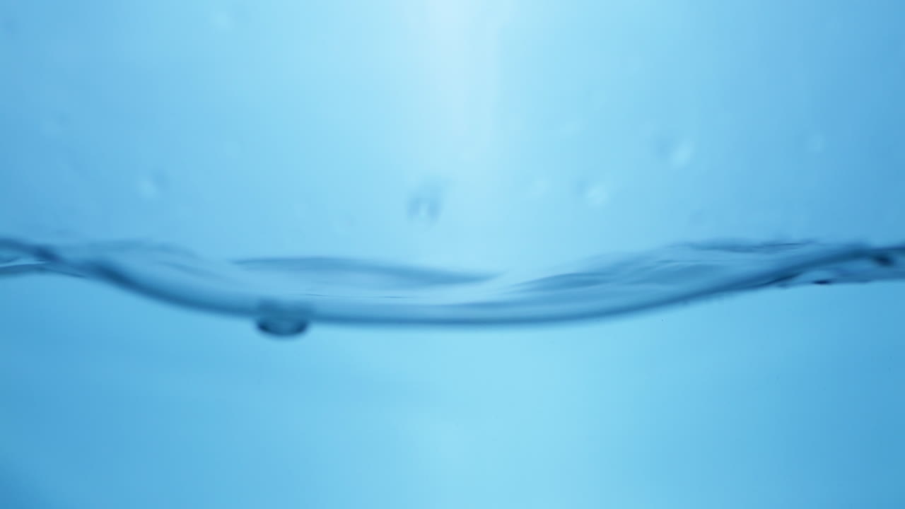파란색 배경으로 표면에 있는 물의 파도_ 느린 움직임