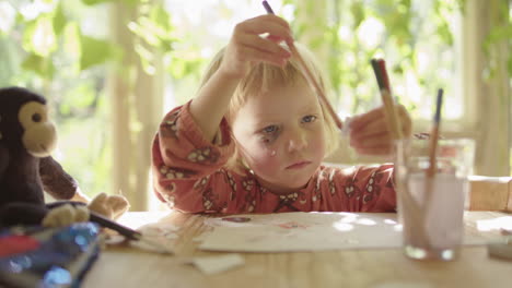 a cute child with a bruised eye creates art in a sunny conservatory, with monkey