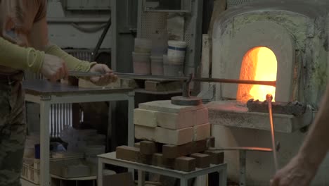 blowing glass artist working in furnace in murano, venice italy