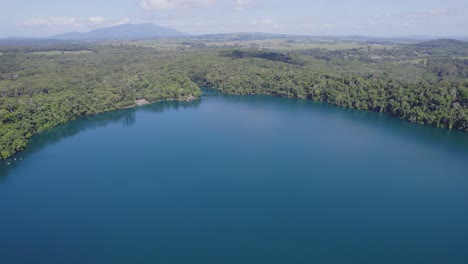 aerial view over lake eacham with serene water in atherton tableland, queensland, australia - drone shot