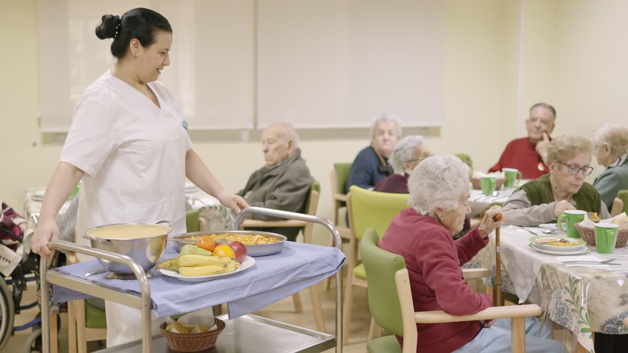 Cook entering with food to the dining room of geriatric
