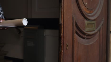 woman delivering a poster in a cardboard tube