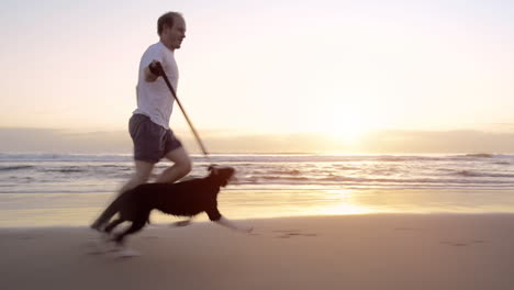 man running with his dog on a beach at sunrise
