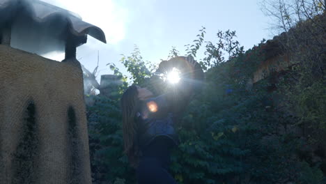 morena mujer sosteniendo un teckel miniatura hound dog raza iluminada por el sol retroiluminado