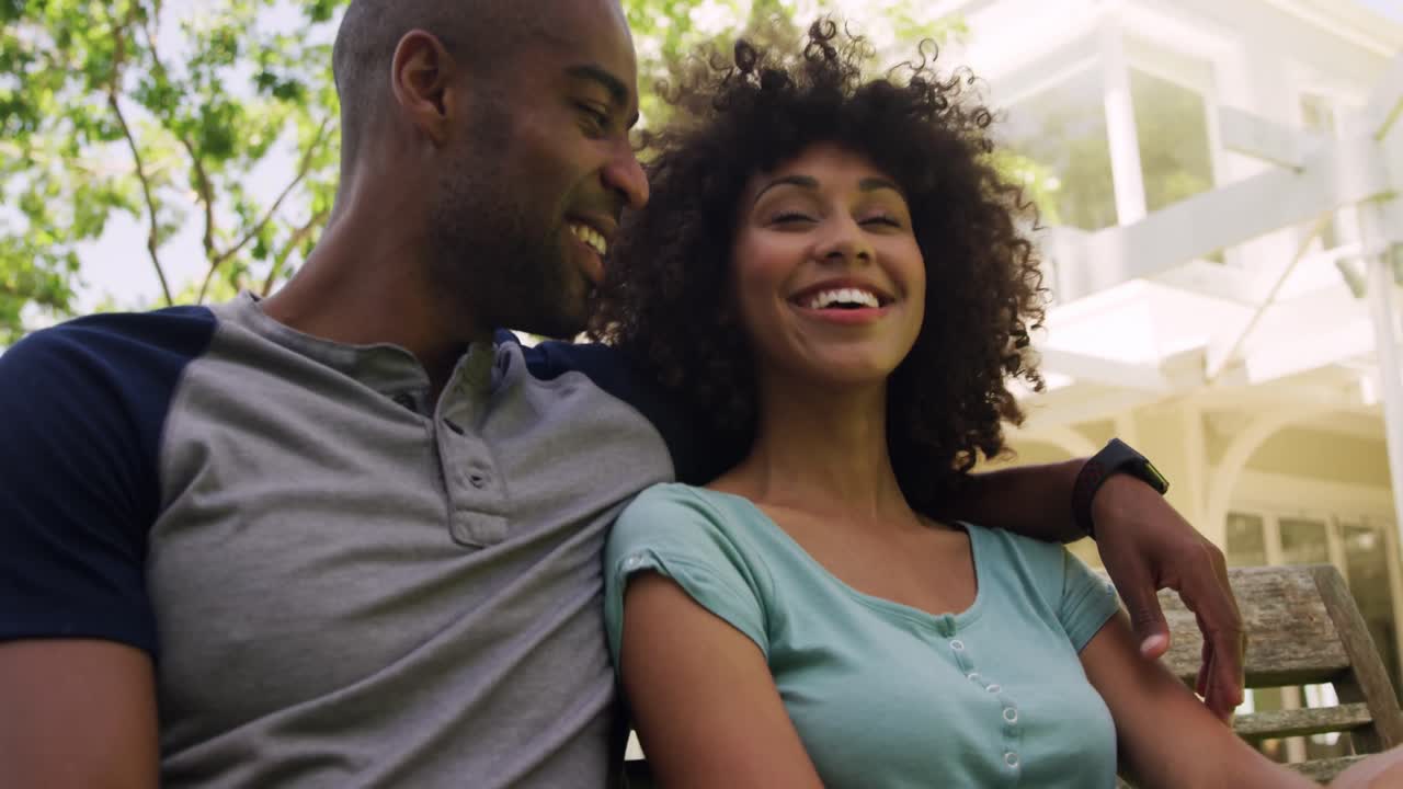 Happy mixed race couple enjoying in the garden during a sunny day