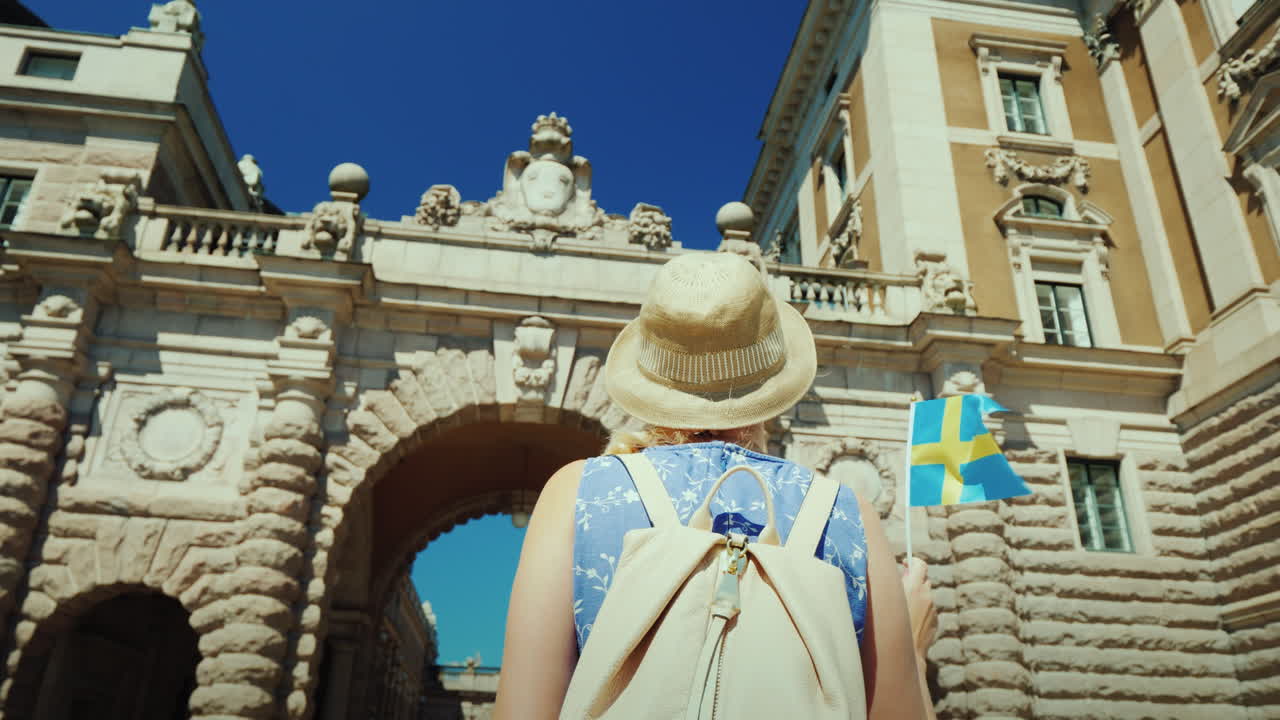 스톡홀름 스웨덴 스웨덴 국기를 든 여성 관광객이 의회 근처의 아치로 이동합니다.