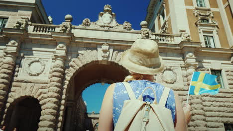 stockholm sweden a female tourist with a swedish flag goes to the arch near the parliament one of th