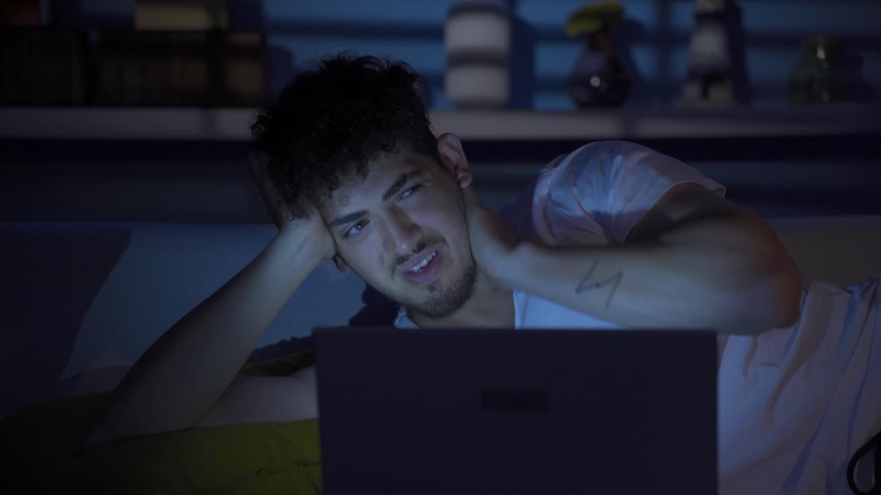 hombre joven con trastorno de ansiedad acostado pensativo en el sofá.