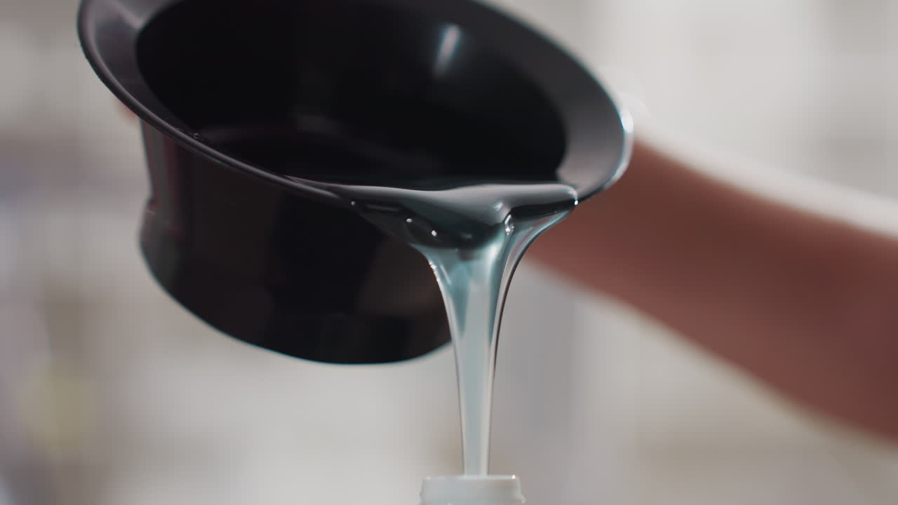 청록색 샴푸가 병에 쏟아지고, 백인 여성의 손이 검은색 깔때기를 잡고 있는 동안 점성 있는 젤이 투명 디스펜서로 흘러 들어가며, 질감과 광택을 클로즈업하고, 부드러운 보케 살롱 배경, 제품 리필