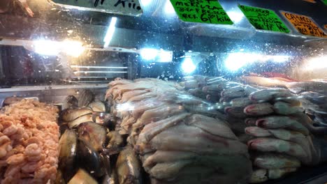 close-up of fresh fish and shrimp behind glass in a popular food market in caracas.