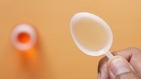 measuring liquid medicine with spoon