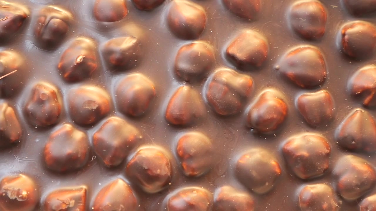 Primo Piano di una Deliziosa Tavoletta di Cioccolato Fondente con Nocciole Intere