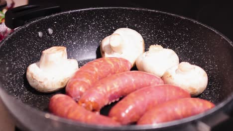 salchichas y setas fritas en una sartén
