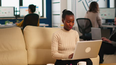 Retrato-De-Una-Mujer-Africana-Escribiendo-En-Una-Computadora-Portátil-Mirando-A-La-Cámara-Sonriendo