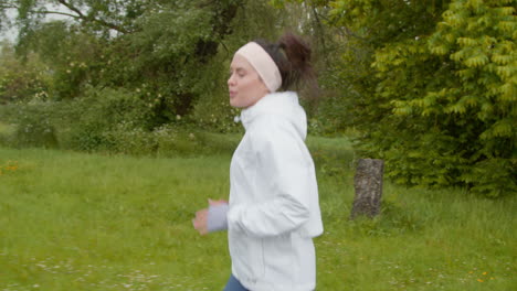 woman wearing headband exercising keeping fit running in countryside or park 1