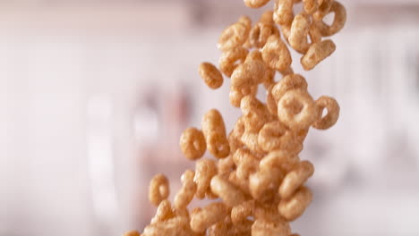 cereales de grano entero crujientes en forma de círculo derramados de la caja cayendo en macro y cámara lenta