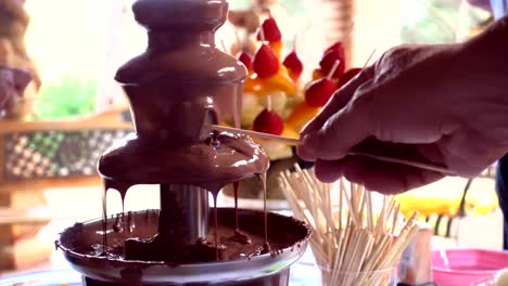sumergiéndose en la fuente de fondue de chocolate