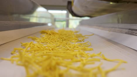fideos deslizándose por un cinturón industrial