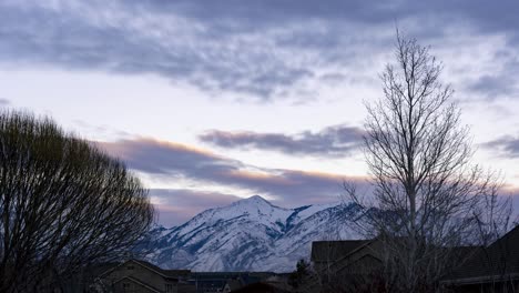 Sunset-to-night-time-lapse-of-snowy-mountains-overlooking-an-urbanized-in-the-valley---static