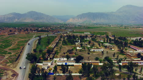 Peshawar,-Pakistan,-Aerial-view-of-busy-mountain-pass-connecting-the-Pak-Afghan-border-through-white-range-with-valley-of-Peshawar,-With-road-a-old-fortress-view