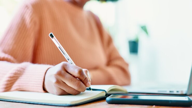 Hands, writing and laptop research by female write