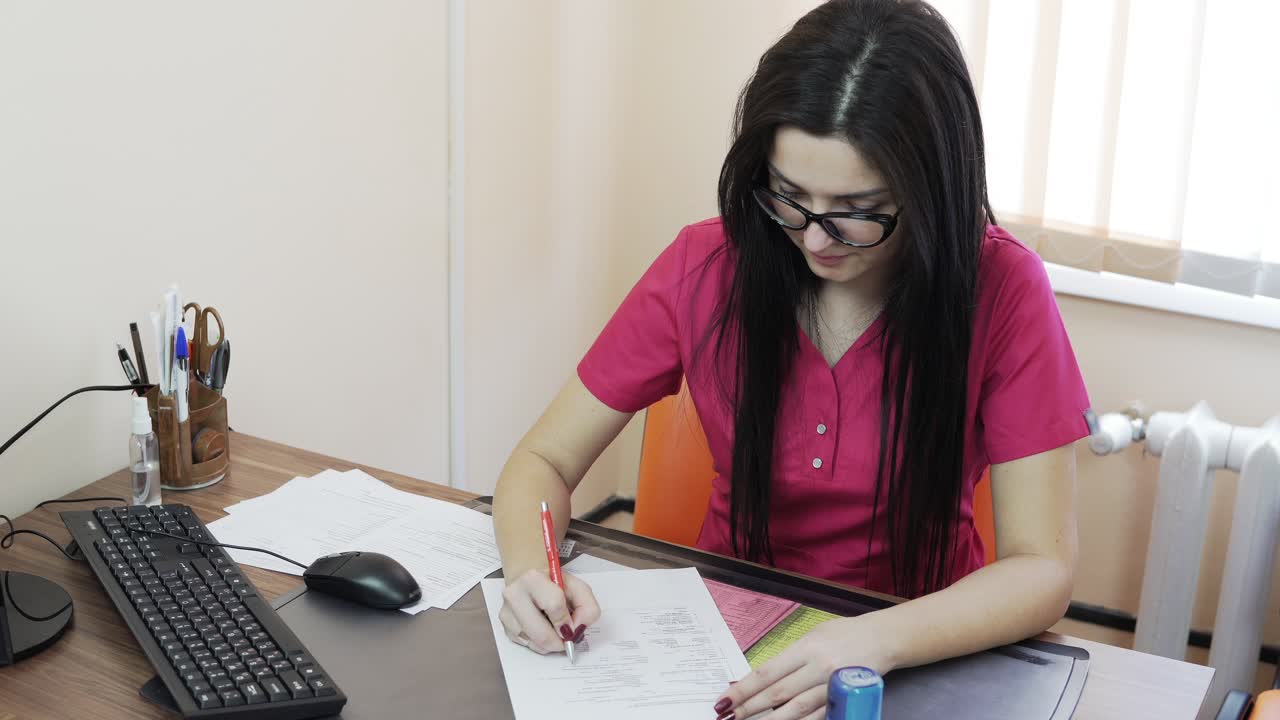 joven médica con gafas y uniforme escribiendo una receta y llenando los formularios en la clínica. concepto de atención médica y medicina