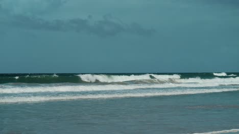 A-scenic-tropical-beach-with-rolling-waves-and-clear-blue-skies-in-the-distance