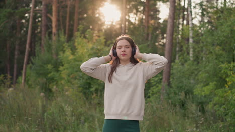 joven disfrutando de la música en el bosque