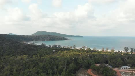 Exóticas-Colinas-Verdes-Y-Exuberantes-Que-Se-Encuentran-Con-El-Mar-Turquesa-En-La-Bahía-Sarracena-En-Koh-Rong-Sanloem,-Camboya---Toma-Aérea-De-ángulo-Bajo