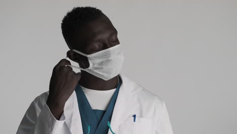 tired african american doctor on grey background.