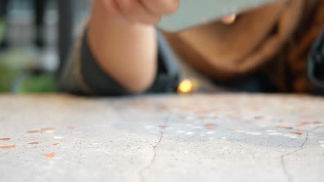 woman picking up a phone from a table