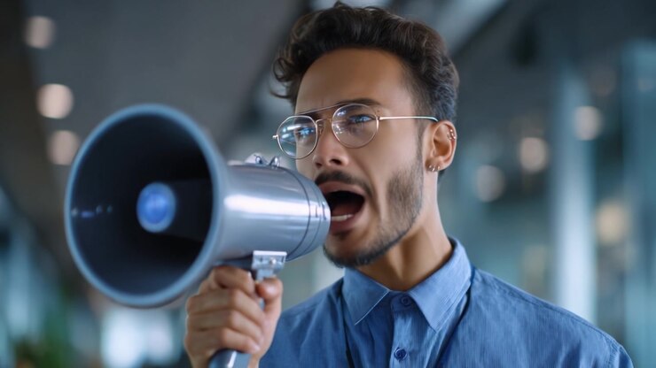 Un oratore coinvolgente usa un megafono per comunicare passione ed entusiasmo in un ambiente dinamico, catturando l'energia del momento e l'interazione con il pubblico.