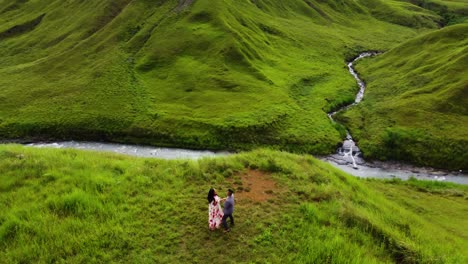 aerial shot a couple dancing on a mountainous landscape