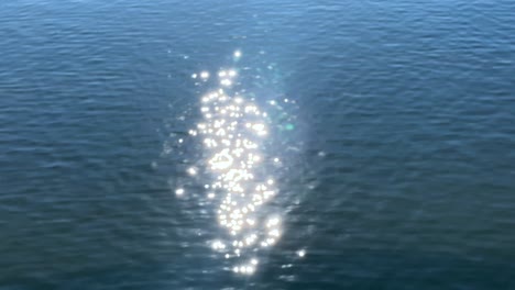 un océano tranquilo que refleja la luz del sol con una débil figura submarina, tokio, japón
