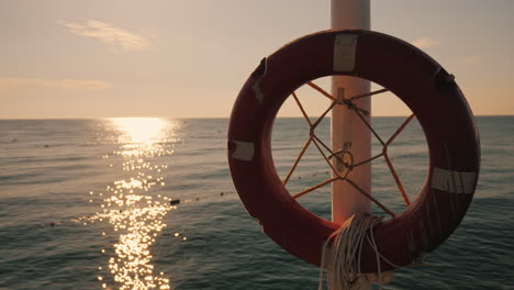 Rettungsring-Hängt-Auf-Dem-Hintergrund-Des-Meeres-Bei-Sonnenaufgang-Am-Morgen-Am-Meer-4k-Video