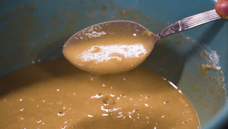 cake batter dripping off of a spoon in slow motion