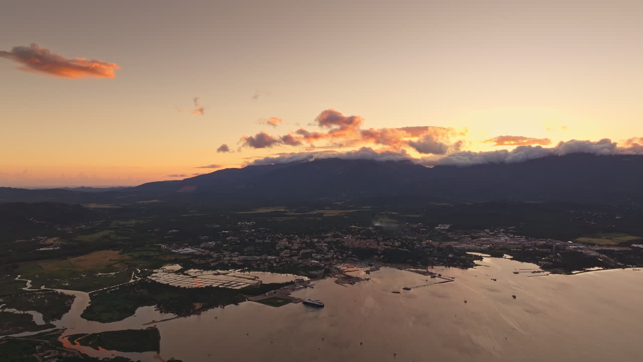 Aerial drone shot over the coastline of Porto Vecchio, southern Corsica, France. Golden hour sunset, warm colorful sky