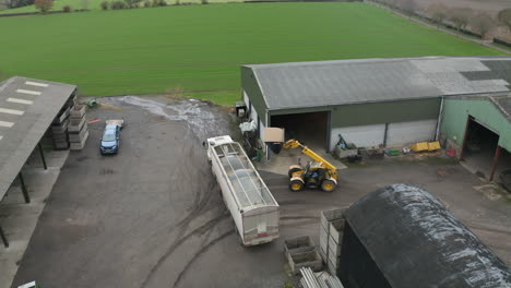 aerial view of farm workers loading grain into truck