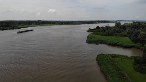 vuelo aéreo sobre oude maas en barendrecht, con un buque de carga en segundo plano