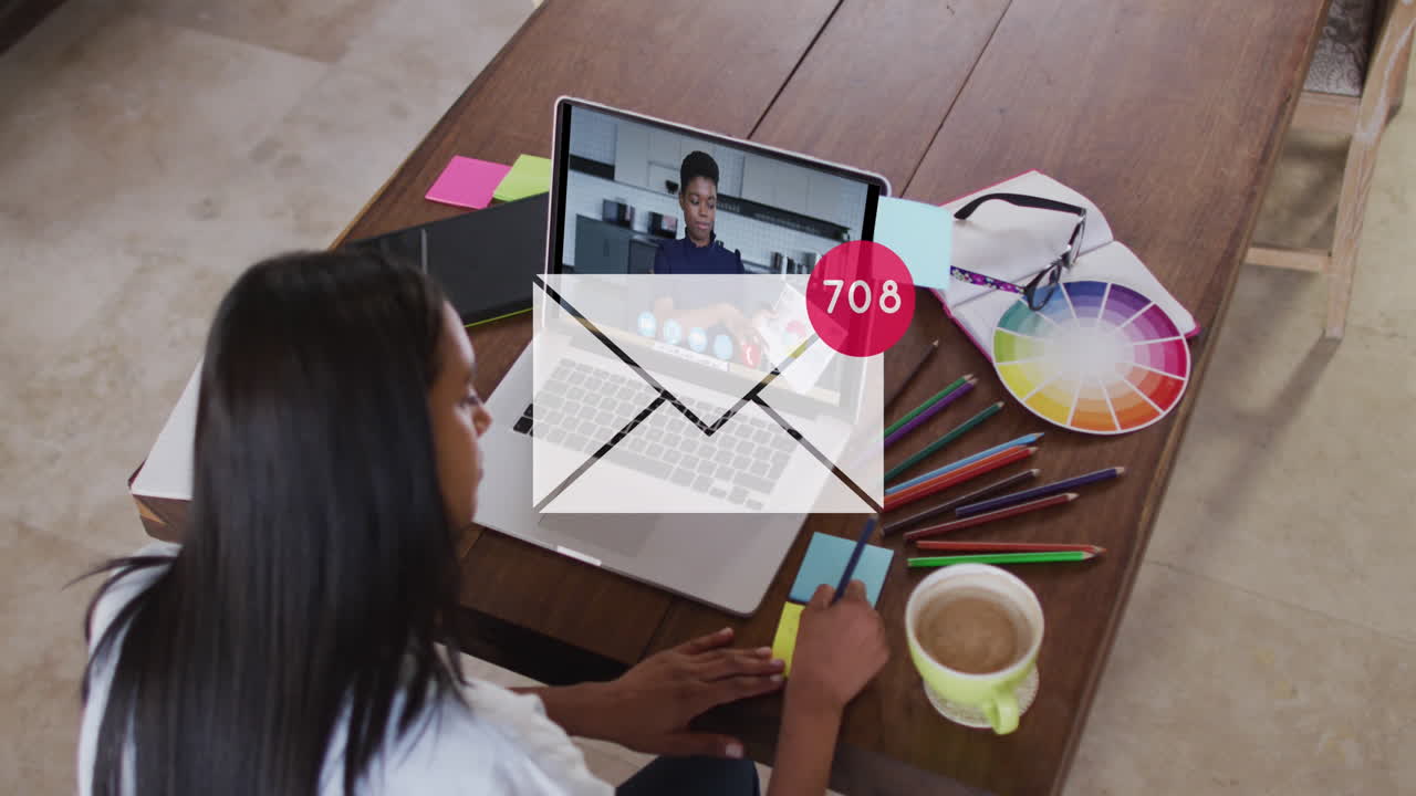 animación de icono de correo y números sobre mujer de negocios biracial usando portátil.