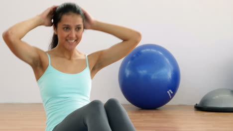 fit brunette doing sit ups on exercise mat